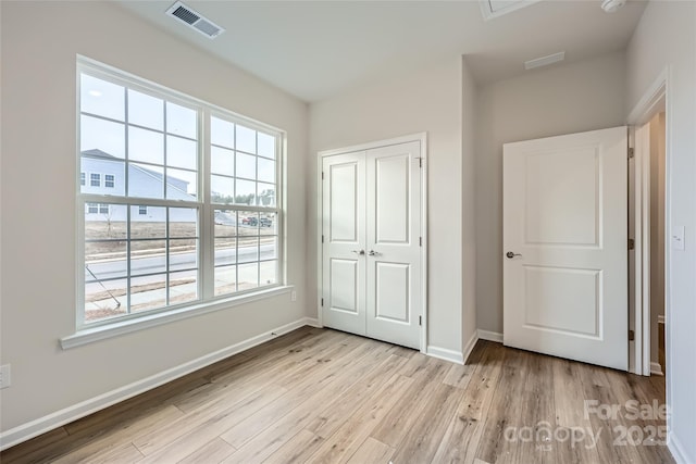 unfurnished bedroom featuring light hardwood / wood-style floors and a closet