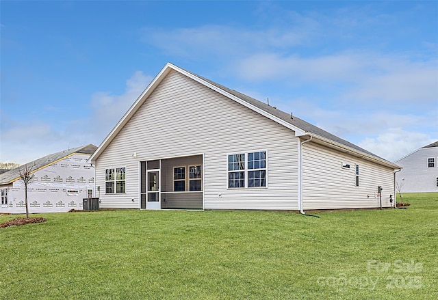 rear view of property with a lawn and central air condition unit