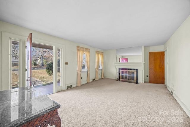 carpeted living room with a tiled fireplace