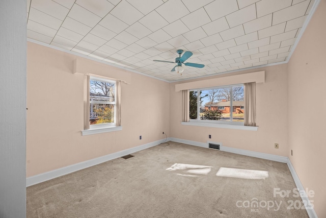 empty room with crown molding, ceiling fan, and light carpet