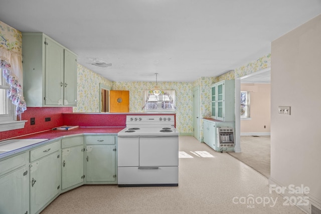 kitchen with heating unit, hanging light fixtures, and white electric range oven