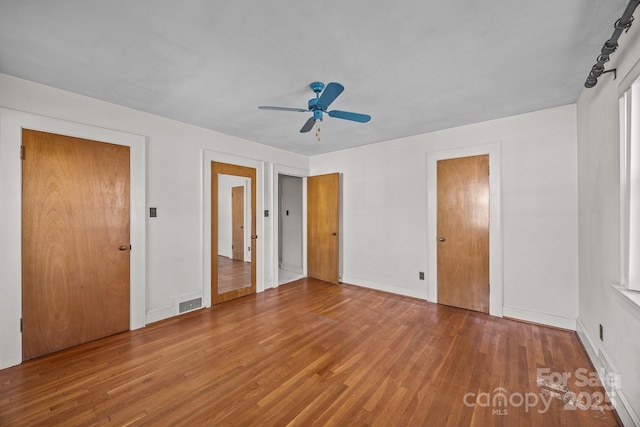 unfurnished bedroom featuring hardwood / wood-style flooring and ceiling fan