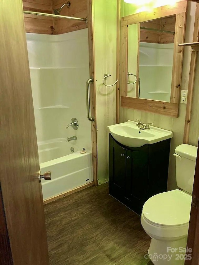 full bathroom with toilet, washtub / shower combination, vanity, and wood-type flooring