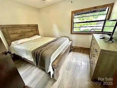 68 Vacation Dr, Whittier, NC 28789 - bedroom featuring multiple windows, wood finished floors, baseboards, and a ceiling fan