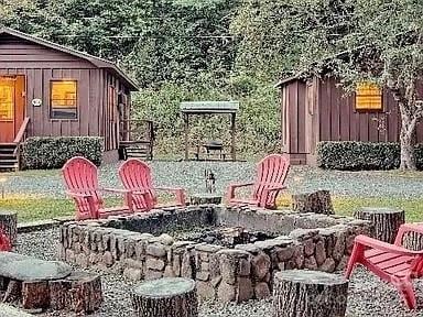68 Vacation Dr, Whittier, NC 28789 - exterior view of a fire pit and board and batten siding