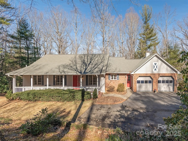 ranch-style home with a garage and covered porch