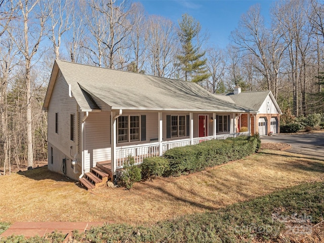 ranch-style house with a garage, a front yard, and covered porch