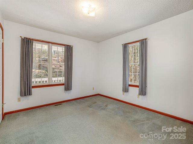 carpeted spare room with a textured ceiling