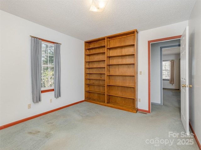 unfurnished bedroom with light carpet and a textured ceiling