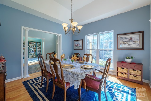 dining space with a healthy amount of sunlight, a notable chandelier, and light hardwood / wood-style floors