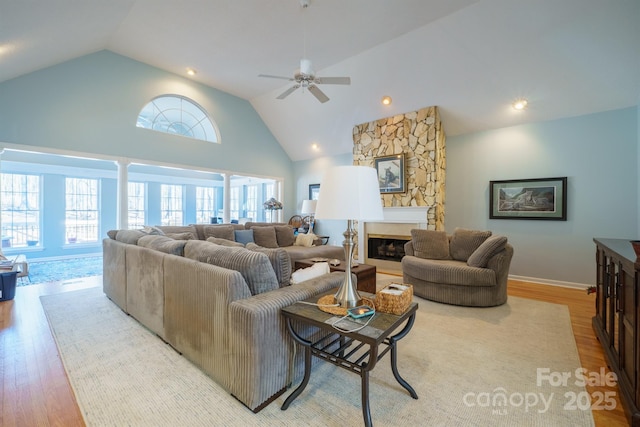 living room with lofted ceiling, a fireplace, and light hardwood / wood-style floors