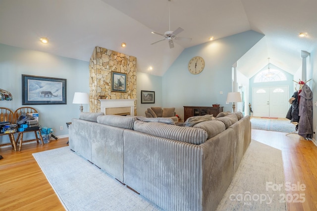 living room with ceiling fan, lofted ceiling, and light wood-type flooring