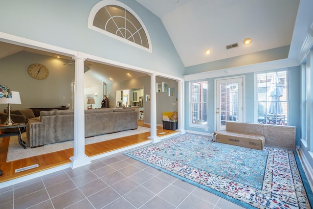 interior space featuring high vaulted ceiling and ornate columns