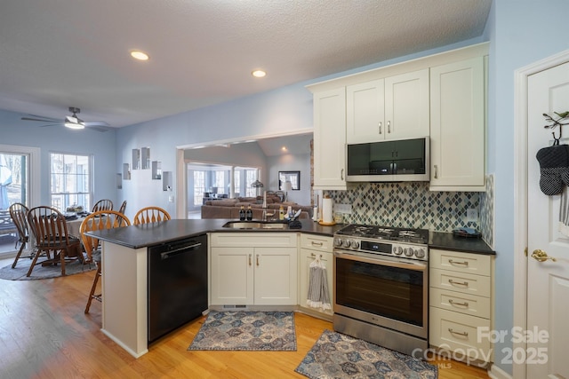 kitchen with appliances with stainless steel finishes, white cabinets, backsplash, and kitchen peninsula