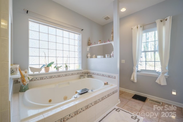 bathroom with tiled tub and tile patterned floors