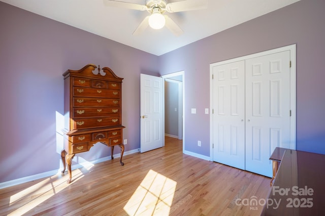 unfurnished bedroom with light wood-type flooring, ceiling fan, and a closet