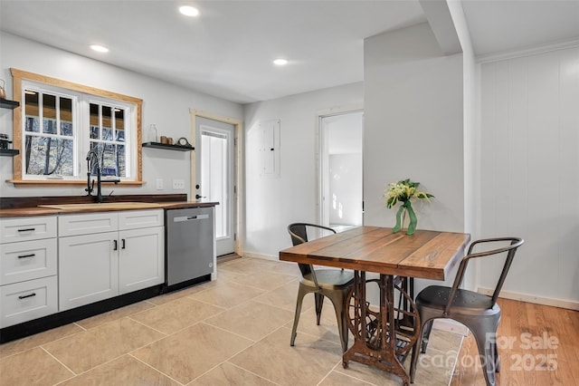 kitchen featuring dishwasher, sink, and white cabinets