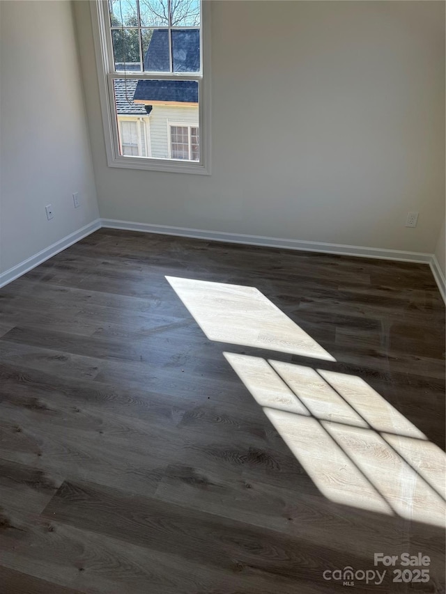 unfurnished room with baseboards and wood finished floors