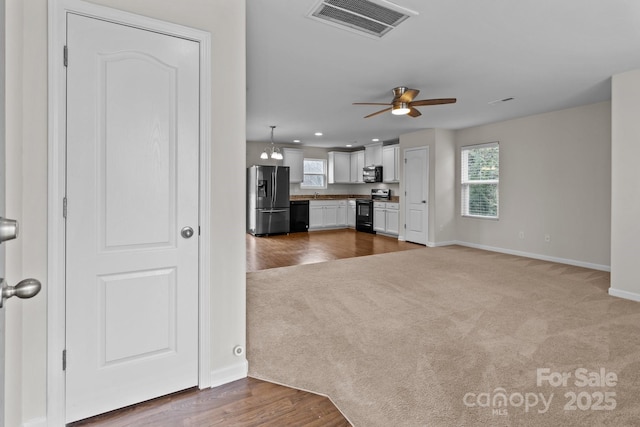 unfurnished living room with ceiling fan and carpet flooring