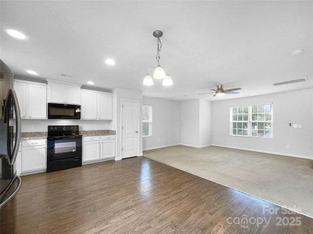 kitchen featuring pendant lighting, dark wood-type flooring, black appliances, white cabinets, and ceiling fan with notable chandelier