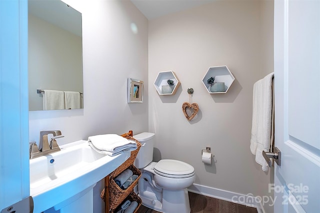 bathroom featuring sink, hardwood / wood-style flooring, and toilet