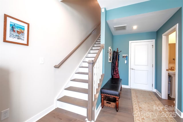 stairs featuring hardwood / wood-style floors