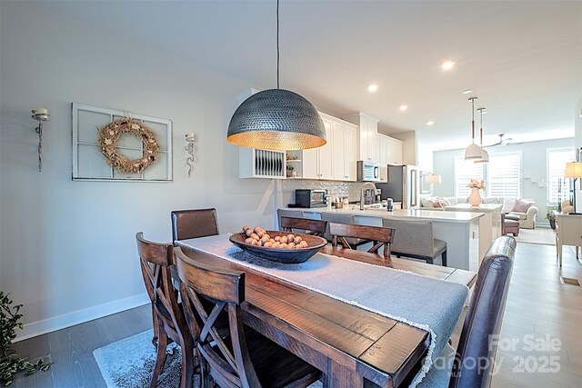 dining space featuring dark wood-type flooring and sink