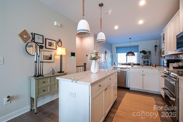 kitchen featuring appliances with stainless steel finishes, pendant lighting, white cabinets, and kitchen peninsula