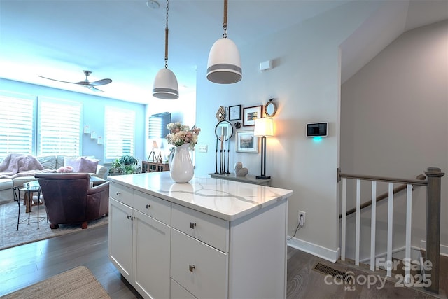 kitchen with white cabinetry, a kitchen island, dark hardwood / wood-style flooring, and decorative light fixtures