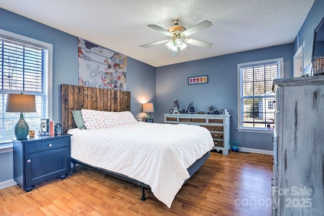 bedroom featuring hardwood / wood-style floors, a textured ceiling, and ceiling fan