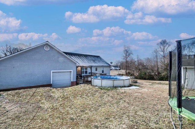 rear view of property with a trampoline