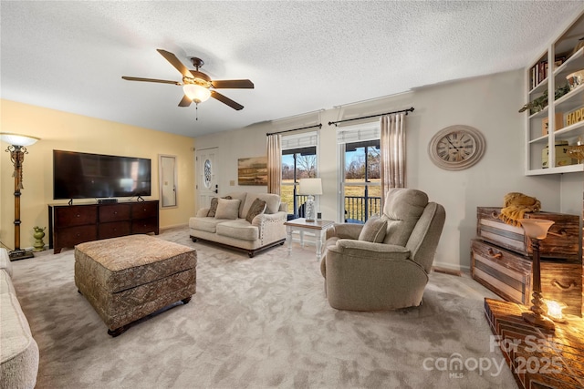 living room with ceiling fan, light carpet, and a textured ceiling