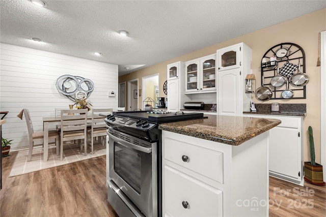 kitchen featuring white cabinets, a kitchen island, stainless steel range, and dark hardwood / wood-style flooring