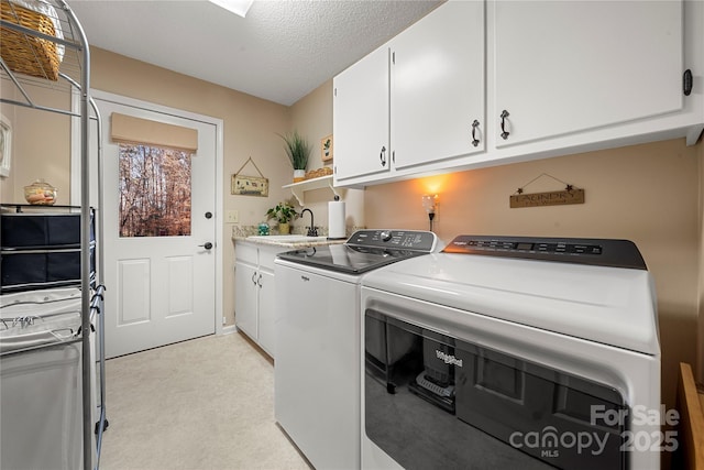 laundry room featuring sink, cabinets, light colored carpet, washing machine and dryer, and a textured ceiling