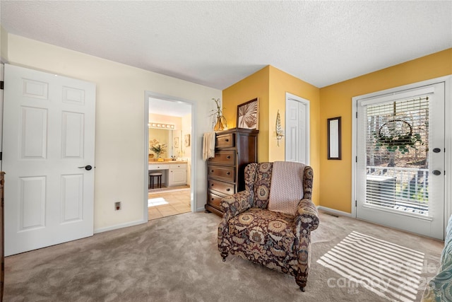 living area featuring light carpet and a textured ceiling