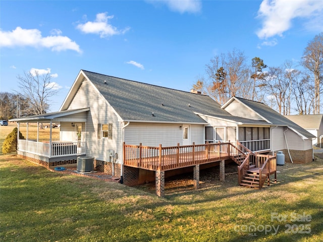 rear view of property featuring a sunroom, cooling unit, a deck, and a lawn