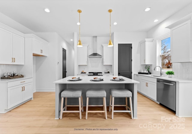 kitchen with white cabinetry, dishwasher, a center island, and wall chimney exhaust hood