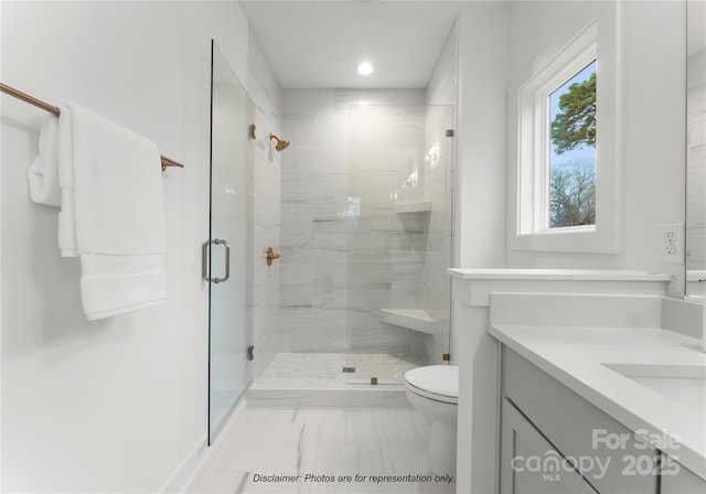 bathroom with vanity, toilet, and a shower with door