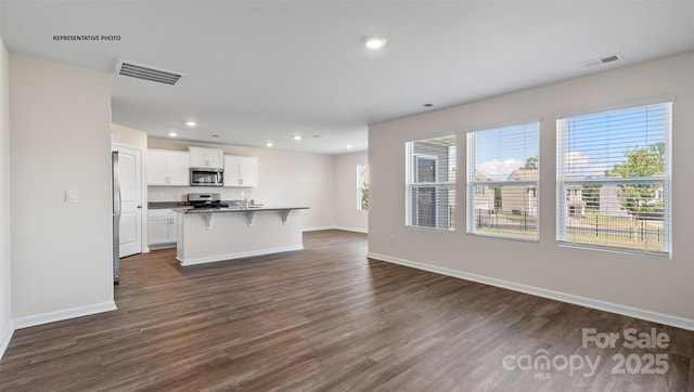 unfurnished living room with dark wood-type flooring