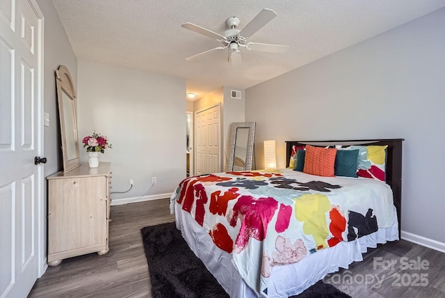 bedroom featuring ceiling fan, dark wood-type flooring, a textured ceiling, and a closet