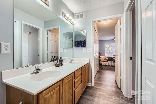 bathroom featuring hardwood / wood-style flooring, vanity, and a textured ceiling