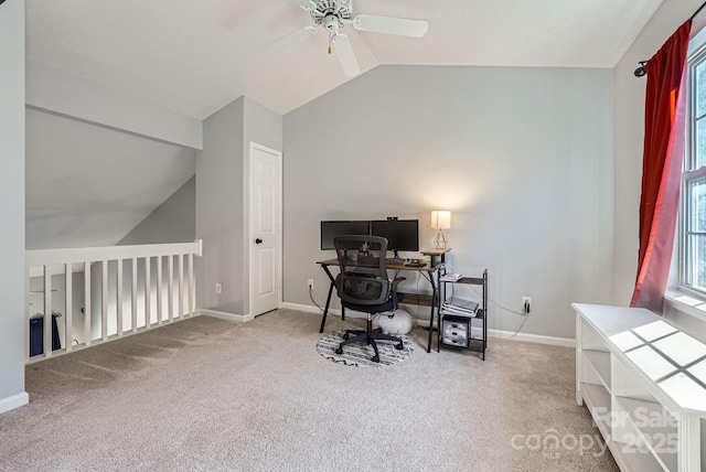 carpeted home office with vaulted ceiling, a wealth of natural light, and ceiling fan