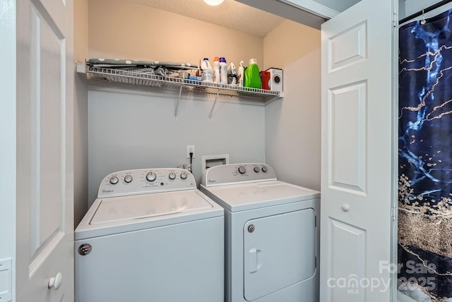 clothes washing area featuring washer and dryer and a textured ceiling