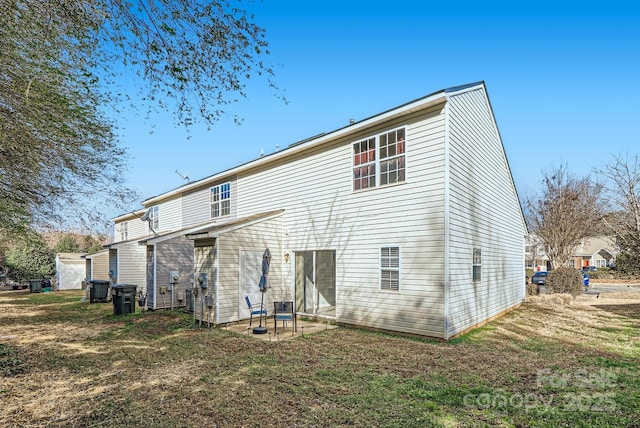 rear view of property with a yard and a patio