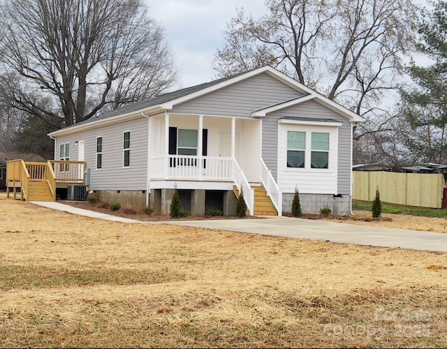 view of front of home with covered porch, crawl space, cooling unit, and fence