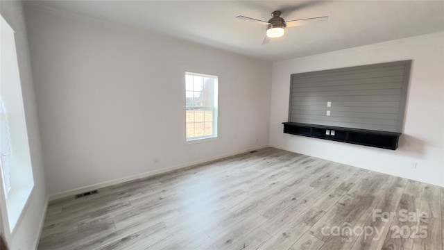 unfurnished living room with visible vents, light wood-style flooring, ornamental molding, ceiling fan, and baseboards