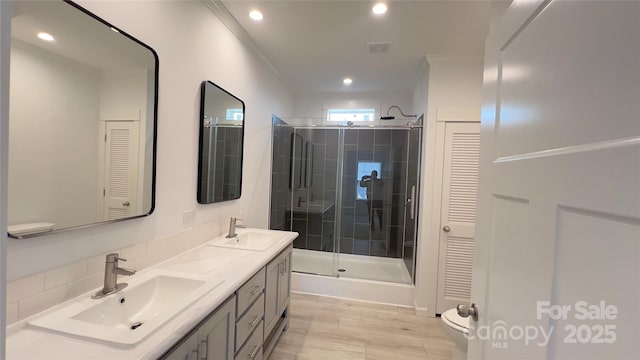 full bathroom featuring a closet, a sink, and crown molding