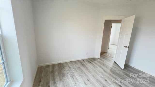 spare room featuring baseboards and light wood-style floors