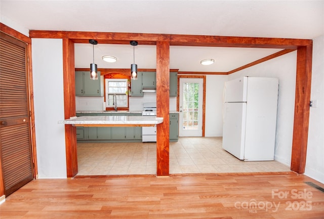 kitchen featuring sink, green cabinets, pendant lighting, white appliances, and light hardwood / wood-style floors