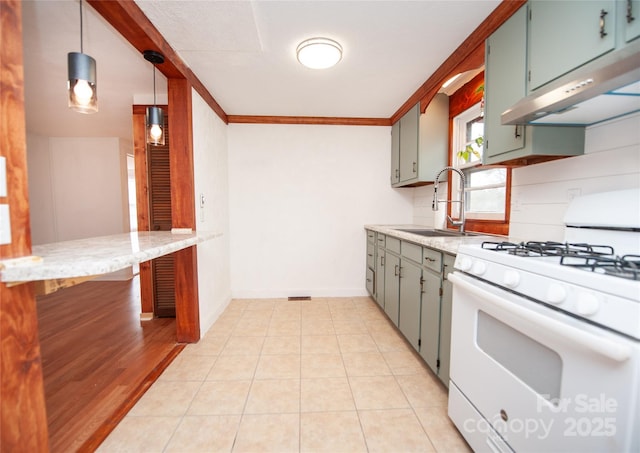 kitchen with light tile patterned flooring, sink, white gas stove, hanging light fixtures, and ornamental molding